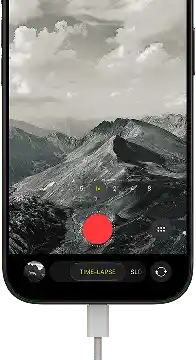 iPhone 18 Pro, front exterior, displaying a mountainous landscape, with the camera mode overlay in Time-Lapse mode, with power cable attached to charging port