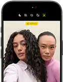 جهاز iPhone 18 Pro، بلون أسود، الجهة الخارجية الأمامية، عارضتان تتخذان وضعية التصوير أمام الكاميرا، استعراضاً لكاميرا Center Stage الأمامية